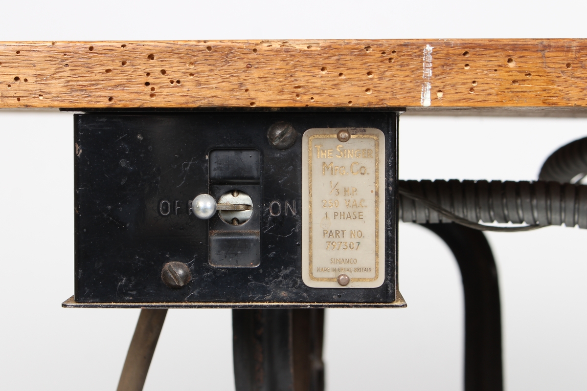 Symaskinbord med trømaskin og elektrisk motor.