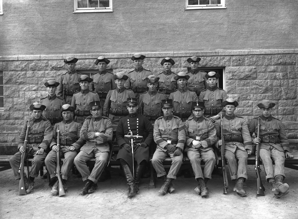 Infanterister vid I 5 i Linköping samlade för fotografering. Uniformerna är av modell 1910 med förändringen att visa gradbeteckningarna på axelklaffar istället för som tidigare vid ärmarna. Odaterat ögonblick från 1920-talet.