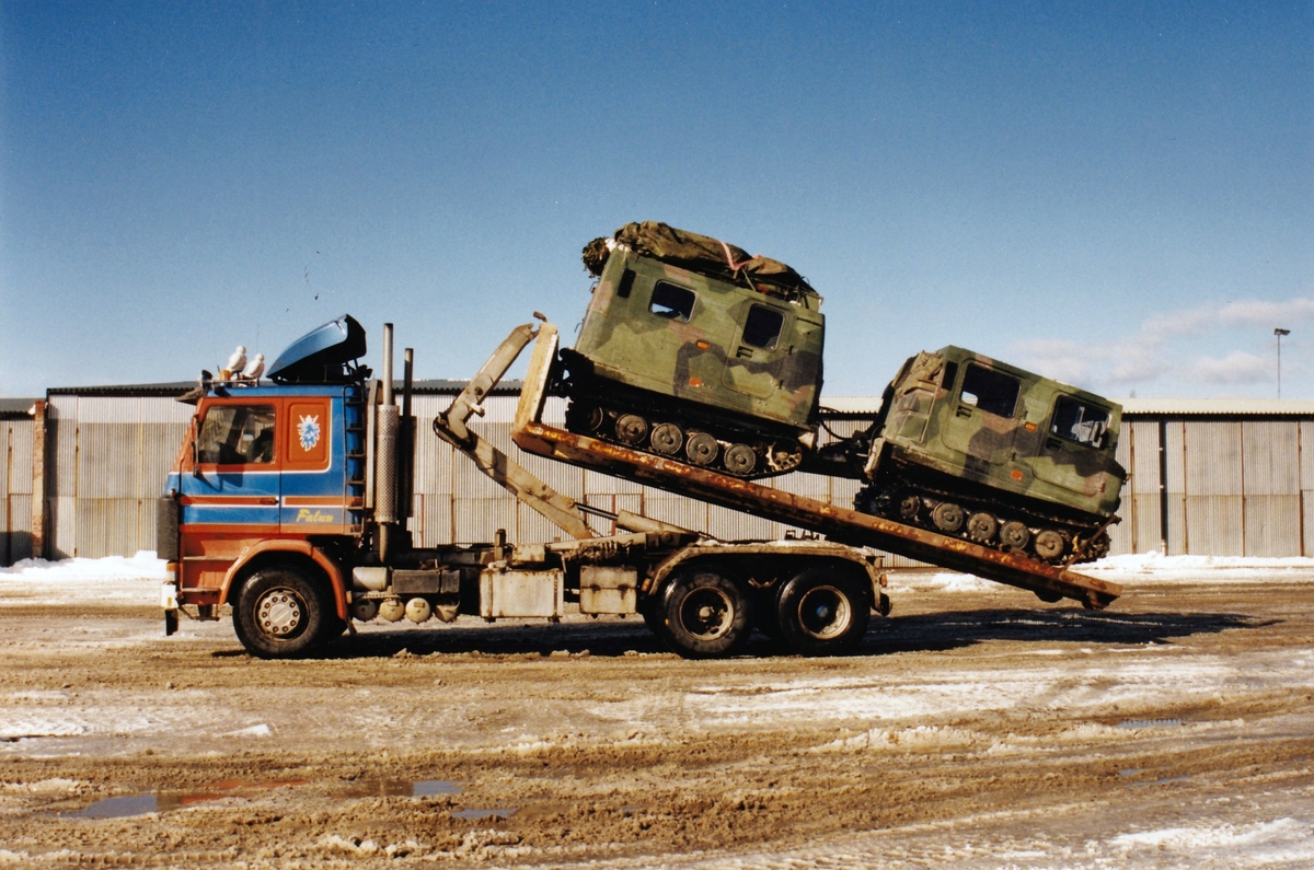 Fältmässig lastning av bandvagn 206 för landsvägstransport i slutet av 1990-talet. Hjullastaren behövs för att bygga tillfälliga lastramper.