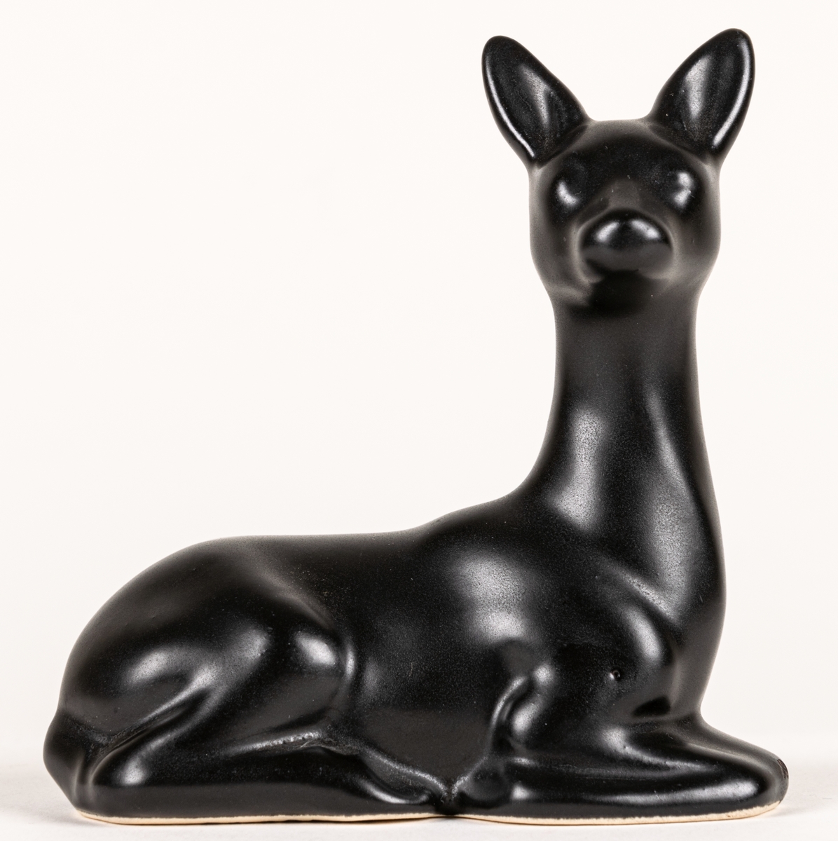 Figurin, svart mangania, föreställande ett liggande rådjur.