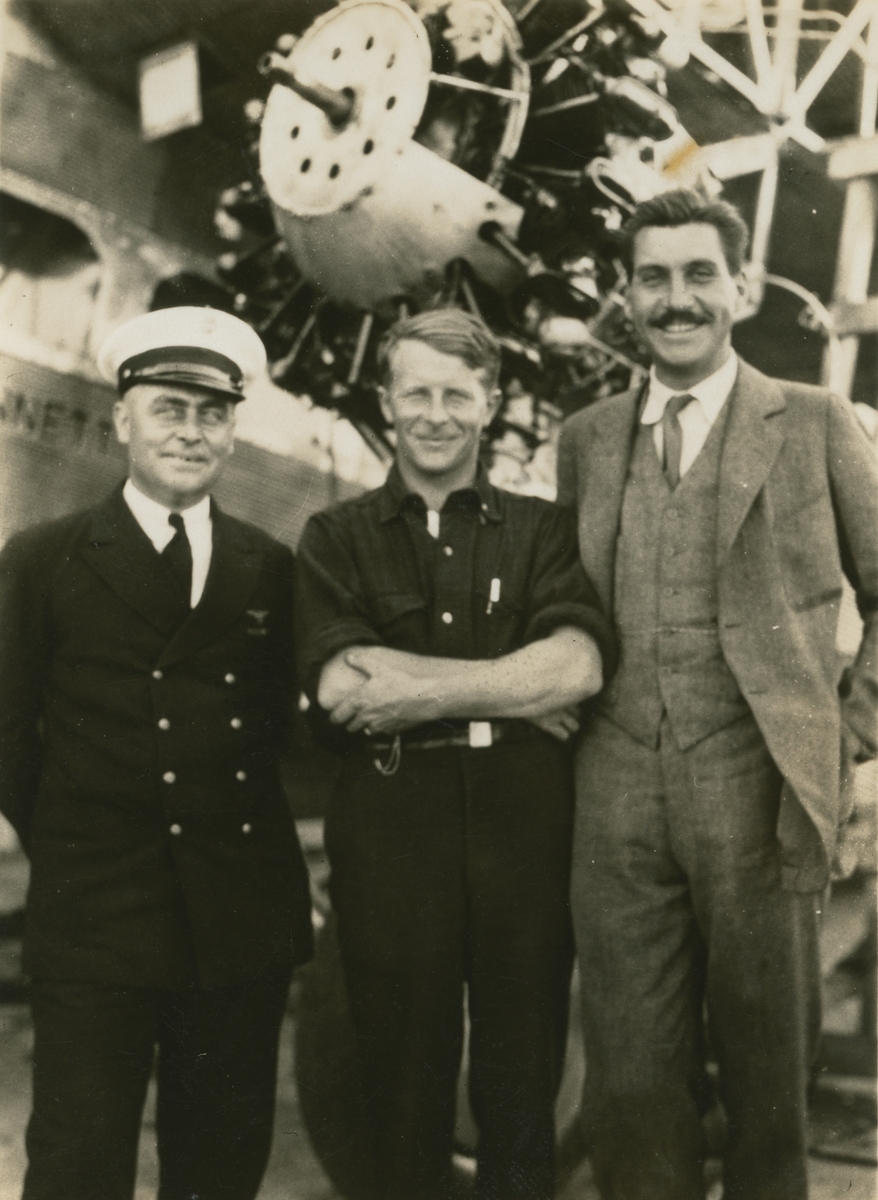 Fotografi från låda märkt Bernt Balchen. Balchen var norsk-amerikansk flygare, polarforskare och militär. Motiv av sydpolsexpedition med Bernt Balchen (i mitten) och två andra män vid flygplan.
