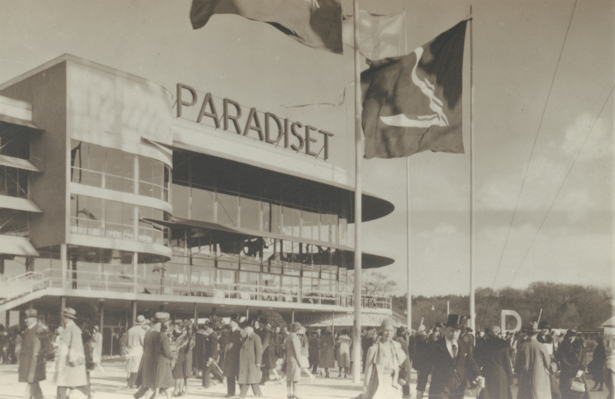 Fotografi från Stockholmsutställningen 1930. Motiv av människor utanför byggnad med skylten "Paradiset".