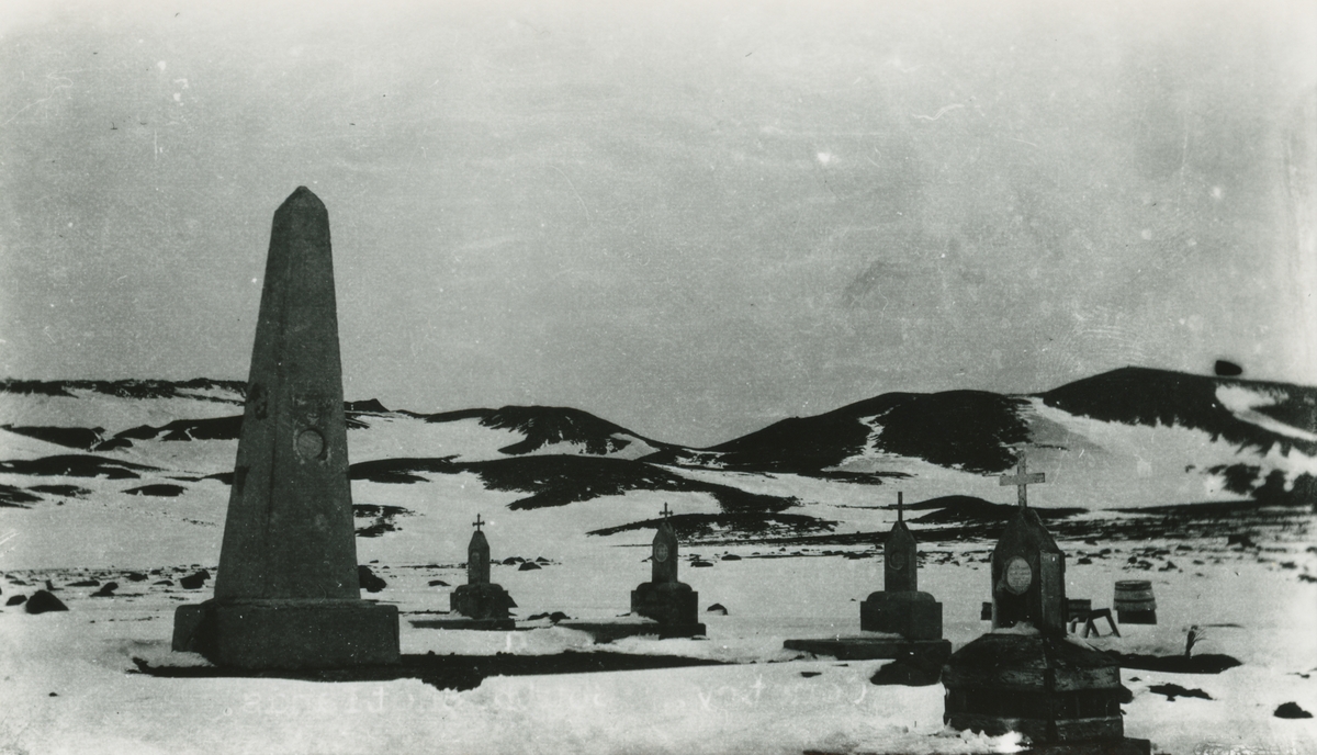 Bild från expedition i Antarktisområdet. Vy över gravplats, snö och berg.