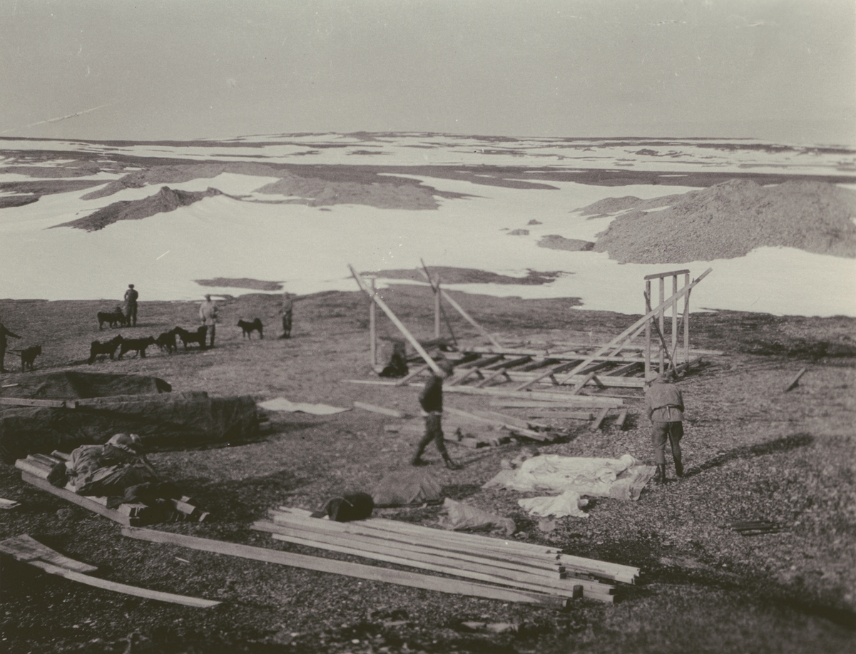 Fotografi från Ahlmannexpeditionen 1931. Motiv av män som bygger hus i öde landskap.