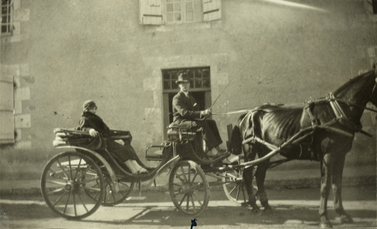 Kvinne (Lucy Egeberg?) er passasjer i hestekjøretøy med kusk, i Morthemer i Frankrike. Kusken heter Luc. Fotografert høsten 1926.