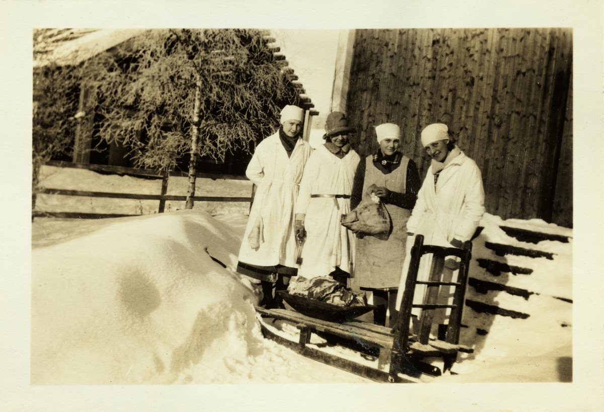 Fire kvinner viser frem resultatet av slakting i 30 minusgrader på Bjerke gård, Hedmark. Fra venstre antagelig Signe Ringnes, Kirsten Omstad, Kitty Tschudi og Mossa Steen(?). Fotografert vinteren 1928.