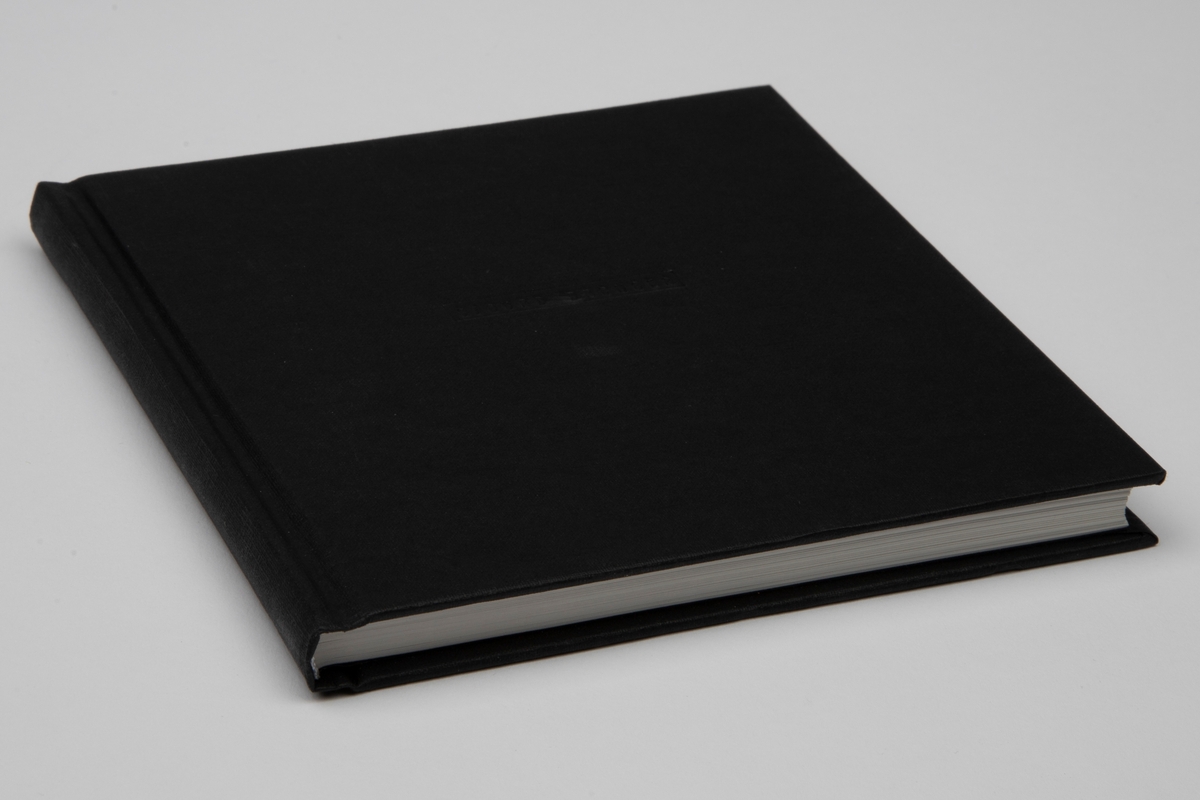 Smykke i eske med bok og folder. En kvadratisk svart eske inneholder et smykke, en bok og en folder. 

Esken har en opptrekksnøkkel preget på lokket.
Smykket er en forgylt pin i form av en skrue. Det er festet på innsiden av lokket.
Bokenhar svart pappbind med "Sigurd Bronger" preget på forsiden. Den har 103 sider, norsk og engelsk tekst, farge- og svart-hvit fotos.
Folderen er i tynn, gråmelert kartong med en opptrekksnøkkel tegnet på forsiden. Den inneholder Sigurd Brongers CV.
