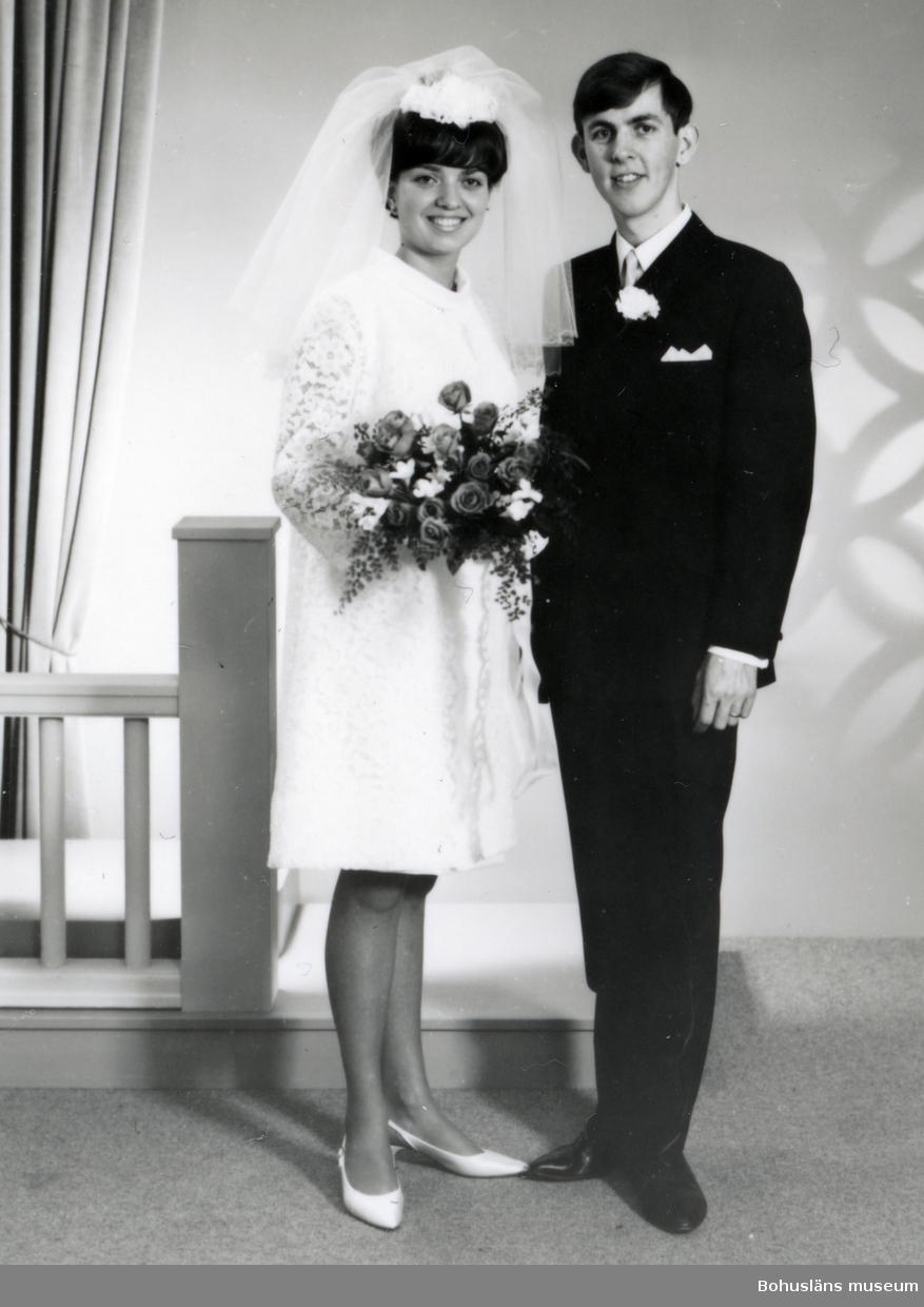 Marinblå kostym med dublla kanpprader och vit duk i vänster bröstficka. Kostymen måttsydd till givarens bröllop. Fodrad med paisley mönstrat tyg. Samma mönster på slips UM033940.

En sprund på baksida.