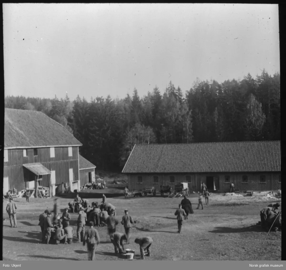 Soldater er samlet på et gårdstun, antageligvis under en militærøvelse i nærheten av Kongsvinger.