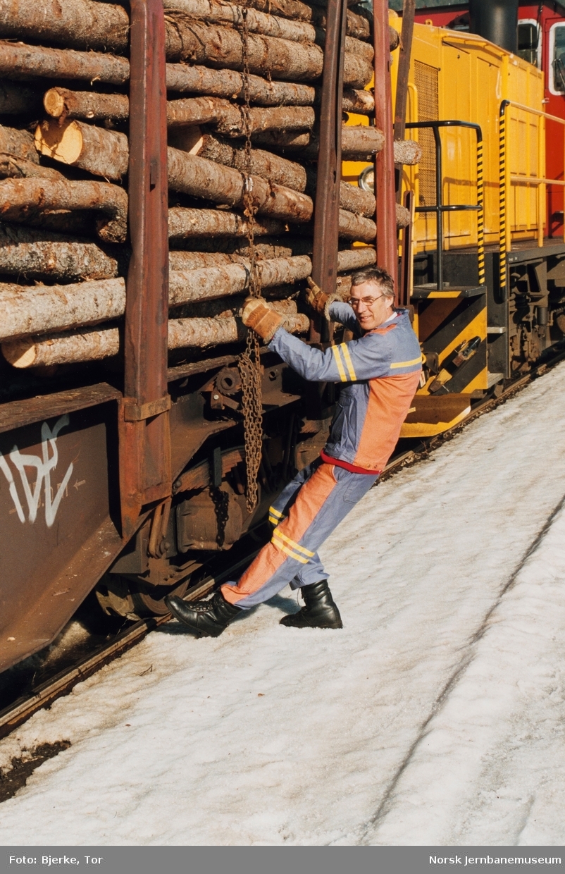 Skiftekonduktør Arvid Øverhaugen kontrollerer bremsene på en fullastet tømmervogn litra Rps før avgang fra Dokka stasjon