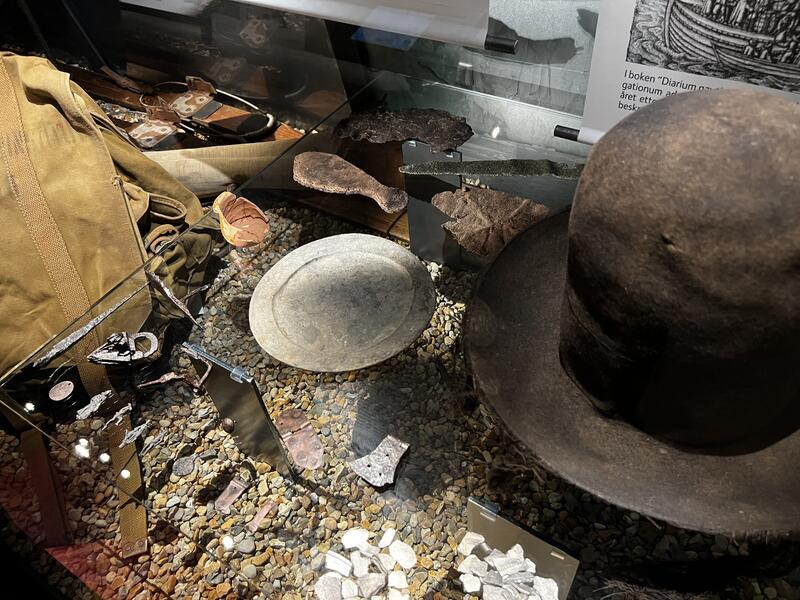Bildet viser en sort hatt sammen med en tallerken og noen andre gjenstander. Hatten kan ha tilhørt Willem Barentsz, mannen som oppdaget Svalbard.