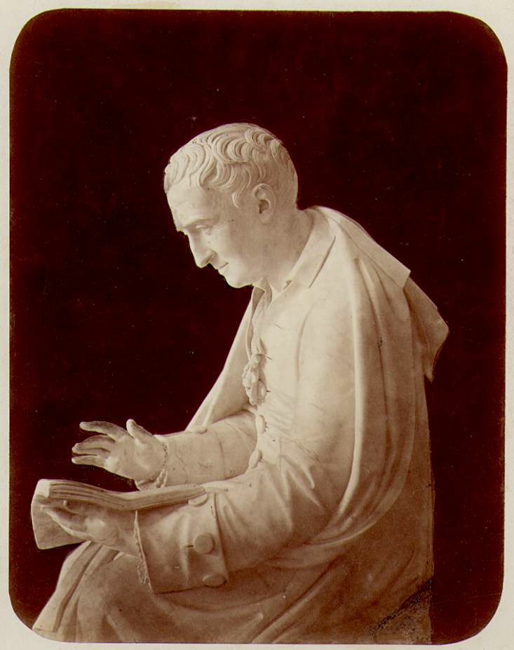 Staty - Carl von Linné sittandes med bok i handen.
