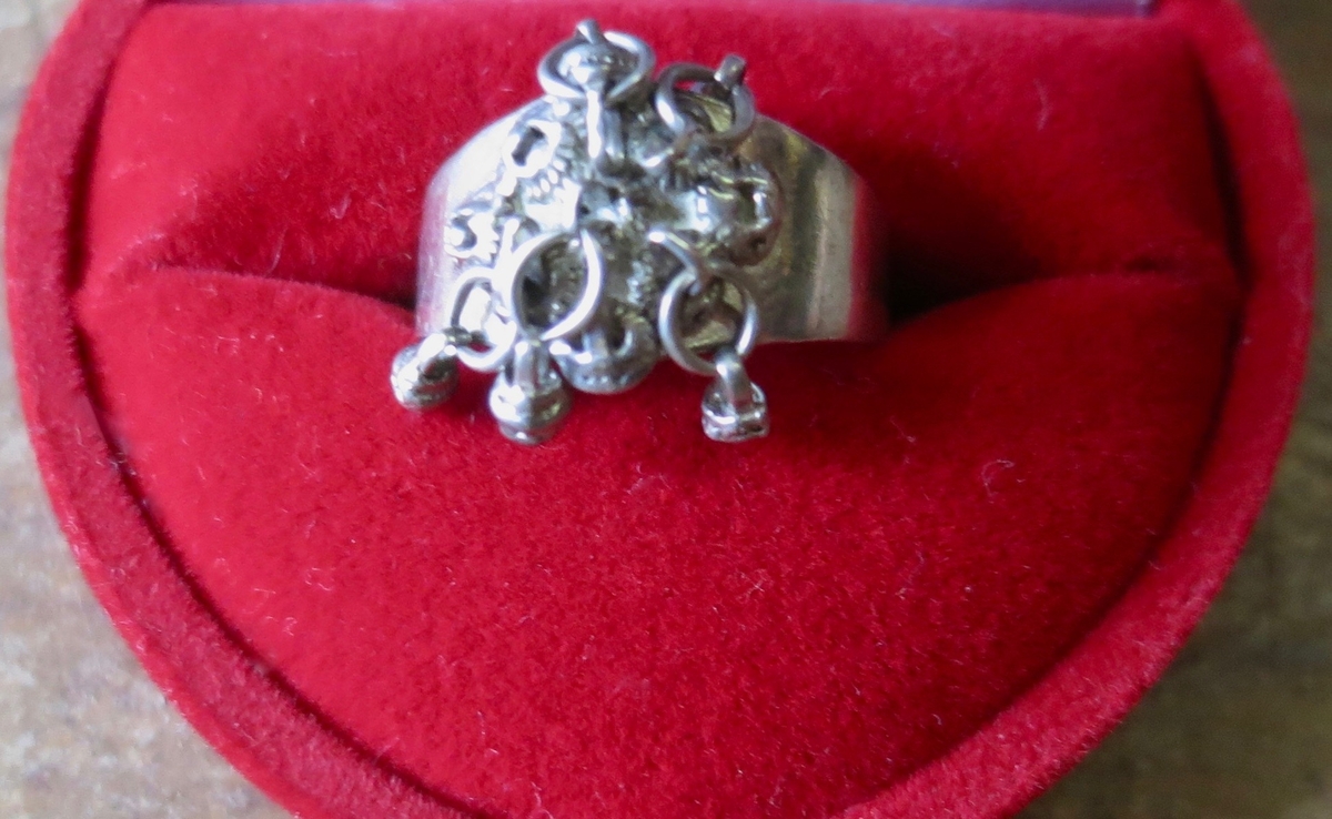Silverring med fem små ringar med varsin liten kläpp. Troligen norskt ursprung, märkt 830.I.F. Användes som "en variant på fingran".