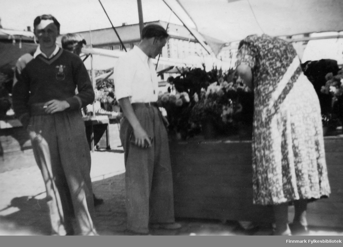 Under en teltduk på et torg? i Åbo står fra venstre, Arne Løvland fra Bjørnevatn. De to andre personene er ukjente. Bildet er tatt i forbindelse med et AUF-stevne i Finland, 1949