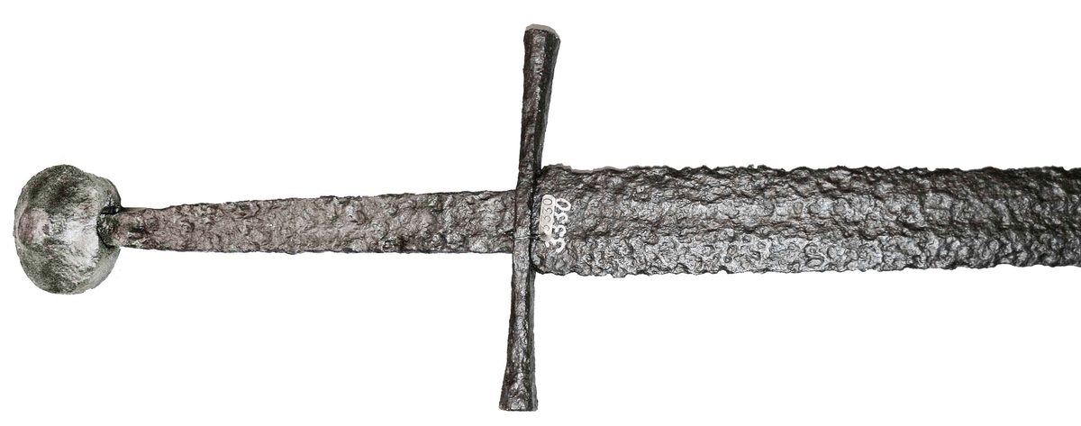 Svärd av smitt järn. Rak parerstång med kulknopp på änden.

Enligt meddelande av Rudolf Cederström är svärdet från 1300-talet.