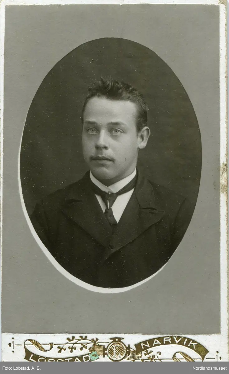 Portrett, brystbilde av en mann i dress og med slips. Nordlandsmuseet