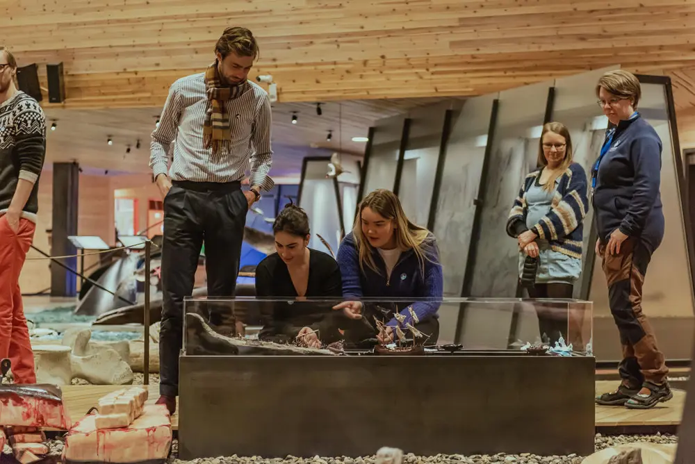 Photo shows a small group studying details in the museum.