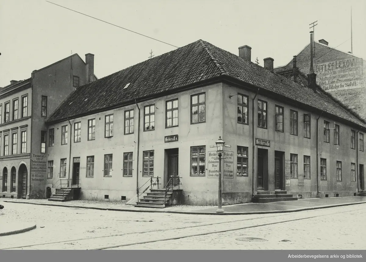 Becker & Co. kolonial og vinhandel. Hjørnet av Store Strandgade (Nå Fred Olsens gate) og Tollbugata 4 i Oslo. Kalt Thomsegården, etter gjestgiver Friderich Thoms. Revet 1930. Arbeidermagasinet/Magasinet for Alle