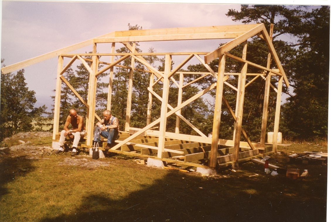 En byggnadskonstruktion till en paviljong på Grännaberget. Två män sitter vi byggnaden och fikar.