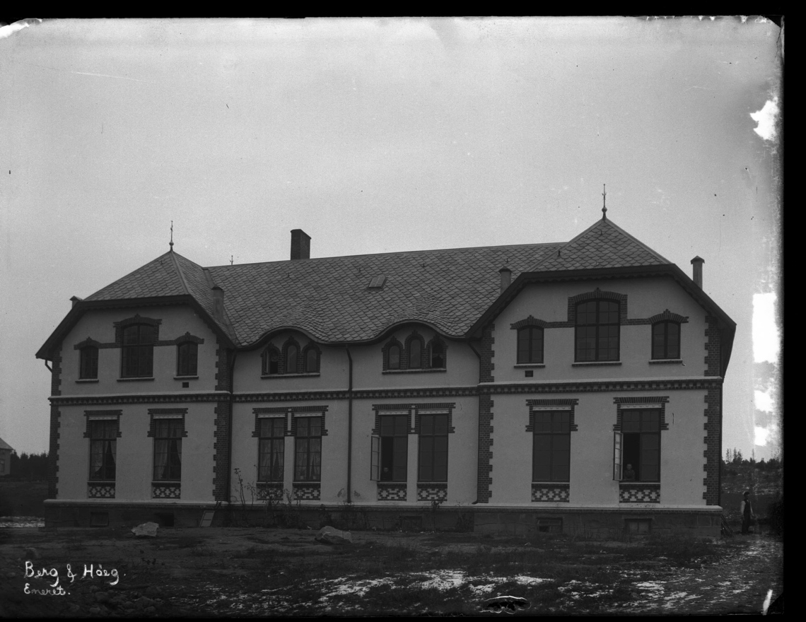 Murbygning på Bastøy. Bastøy skolehjem var i drift fra 1900 til 1970 på øya Bastøy i Oslofjorden. Personer ser ut av vinduene.