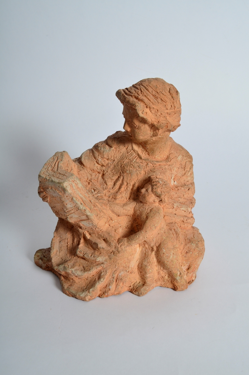 Terrakottafigur som visar ei stjande kvinne som les for eit born. Motiv frå teikning Michelangelo eller Rafael.