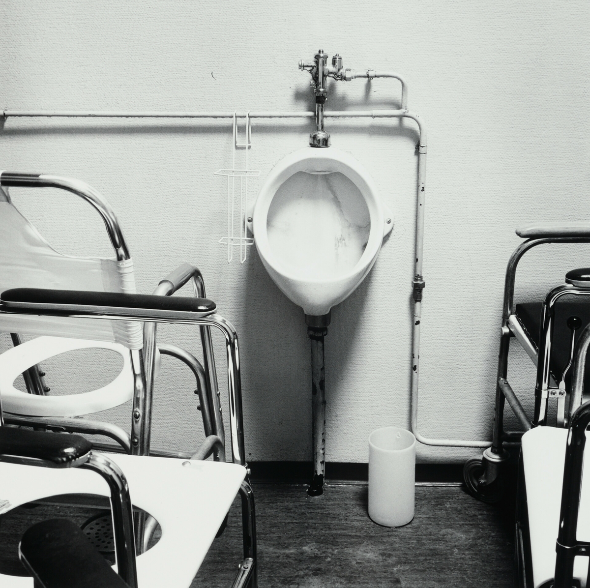 Toalett med urinal og toalettstoler.