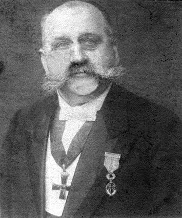 Fotografi av konservator Albert Lange, en mann med stor part, små briller, tynt hår og frimurer-orden rundt halsen.