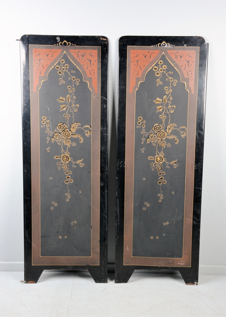 Svart skjermbrett av metall bestående av to paneler. Disse er dekorert med påmalt dekor i form av blomster i en ramme med løkformet overkant og med arabesker.