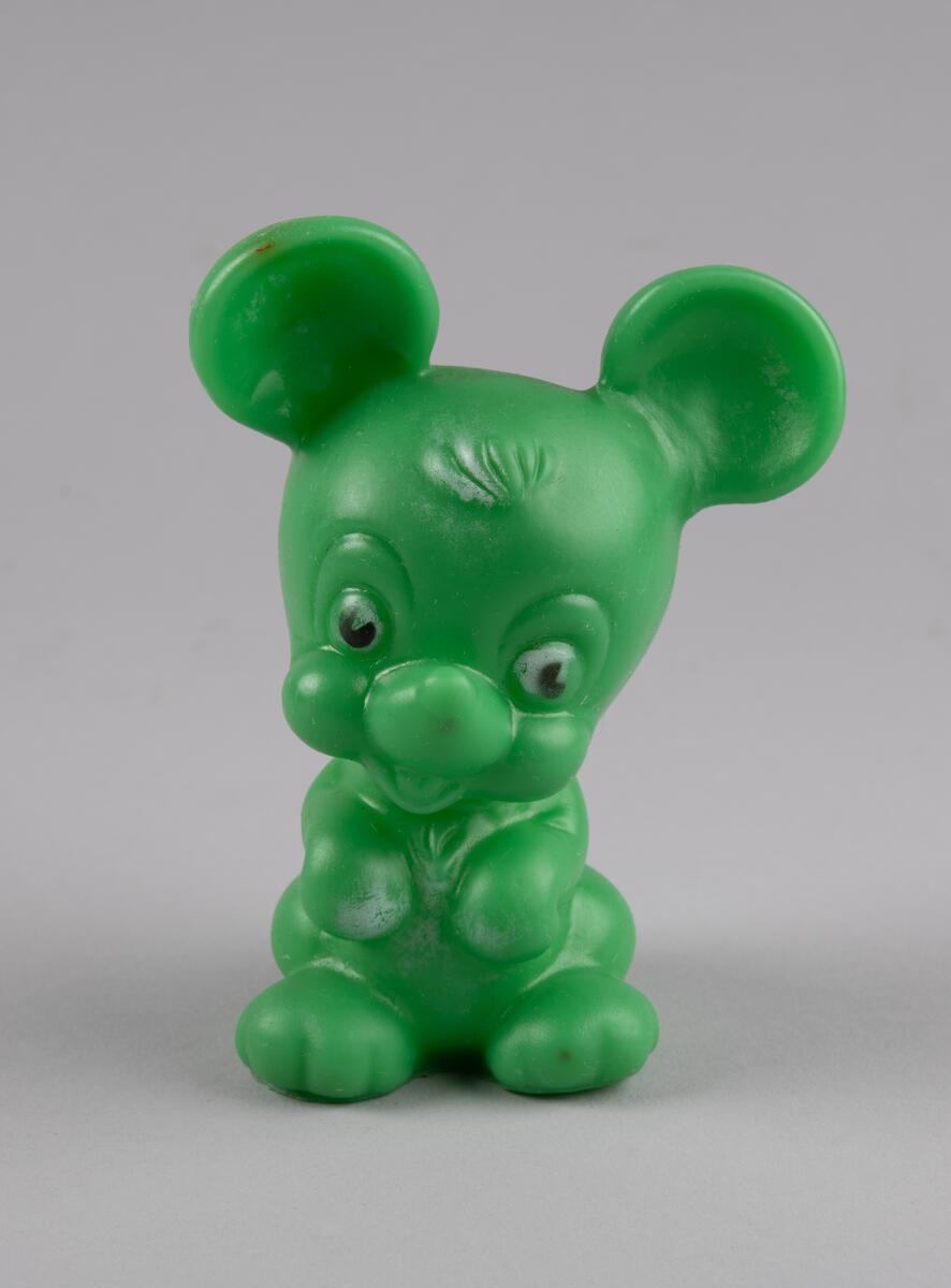 Leketøy av mykplast i form av en sittende, grønn mus med hvite og svarte markeringer.