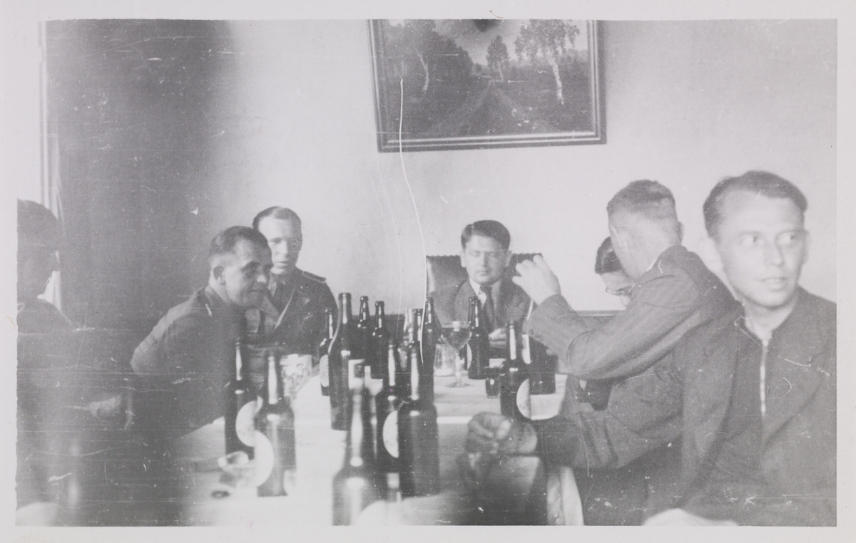 Tyske fangevoktere samlet til øldrikking rundt bord. Nummer to fra venstre sitter Walter Kuntze og helt til høyre i bildet, Wilhelm Hansen (?)