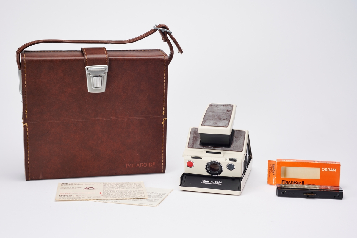 SX-70 Land Camera Model 2 ble produsert av Polaroid på 1970-tallet. Kameraet ligger i original koffert sammen med registreringskort og en pakke blits av typen Flashbar II Prismatic fra Osram.
SX-70 Land Camera revolusjonerte direktebildefotograferingen. De to første modellene er avanserte speilreflekskameraer, som kan foldes sammen. Designet var spesielt og filmen var den første med en ny type bildeframstilling. Det var det første systemet som produserte et ett-trinns direktefotografi. 
Filmene lå enkeltvis i en kassett. Hvert bilde var en forseglet pakke som inneholdt et negativ, kjemikalier og et positiv. Bildet kom automatisk ut av kameraet og kunne sees i løpet av 2 minutter, men trengte noen minutter til før det fikk sitt endelige uttrykk. I filmkassetten var også batteriet som ga strøm til kameraet og blitsen.