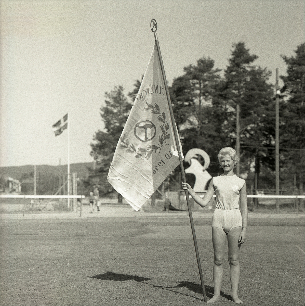 En kvinna med Svenska Frisksportförbundets flagga på Långnäs vid rikslägret i Bollnäs den 12 -19 juni 1959.