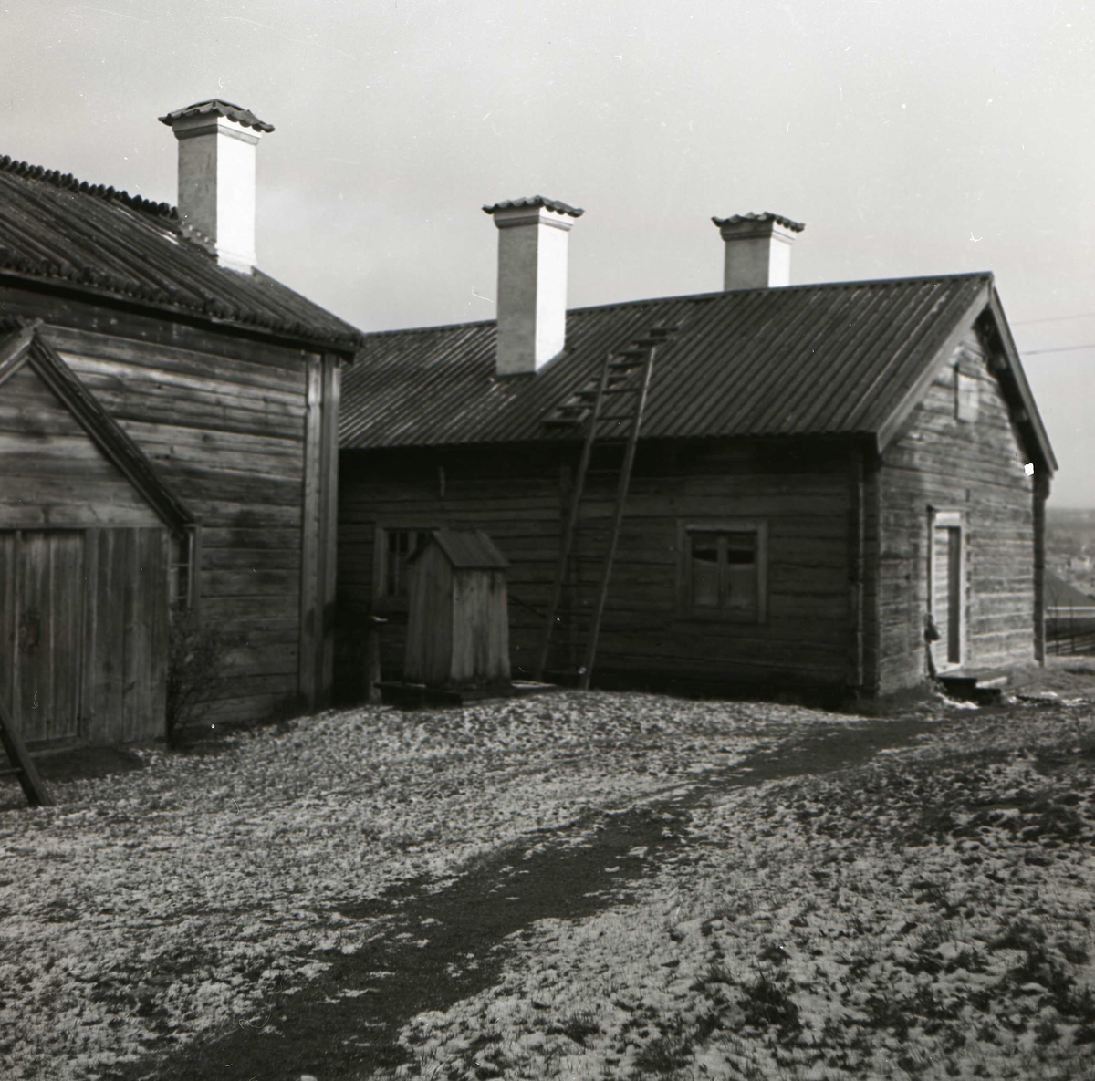 Två byggnader vid Karlsgården i Bondarv är täckta av ett tunt lager snö den 14 maj 1952.