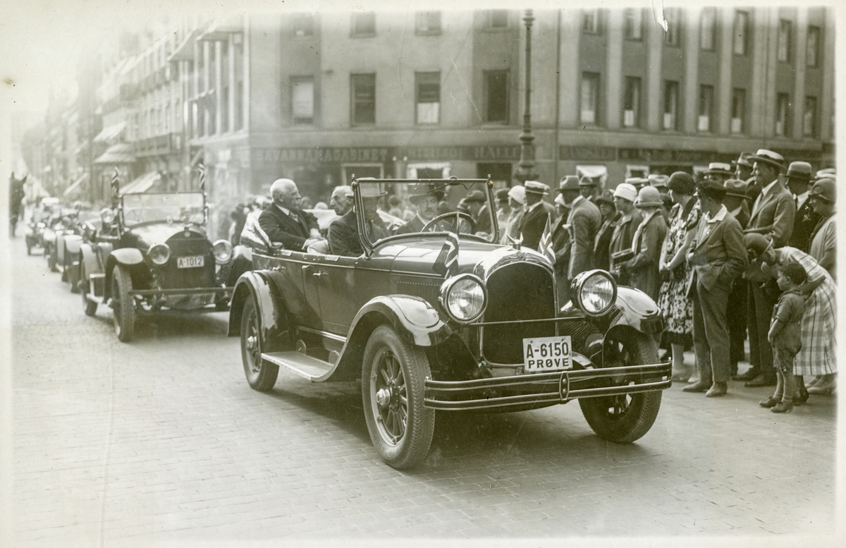 Roald Amundsen i åpen bil i bilkortesje i Karl Johans gate v/Lille Grensen, omgitt av mange tilskuere - Roald Amundsens ankomst til Oslo med S/S "Bergensfjord" efter "Norge"s færden over Polen - 16. juli 1926.