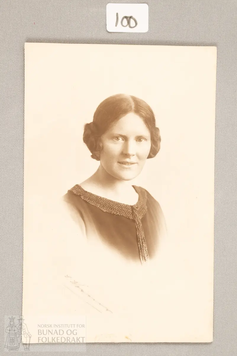Portrettfotografi av Anna Grostøl (1894-1962). Fotografiet er innrammet.