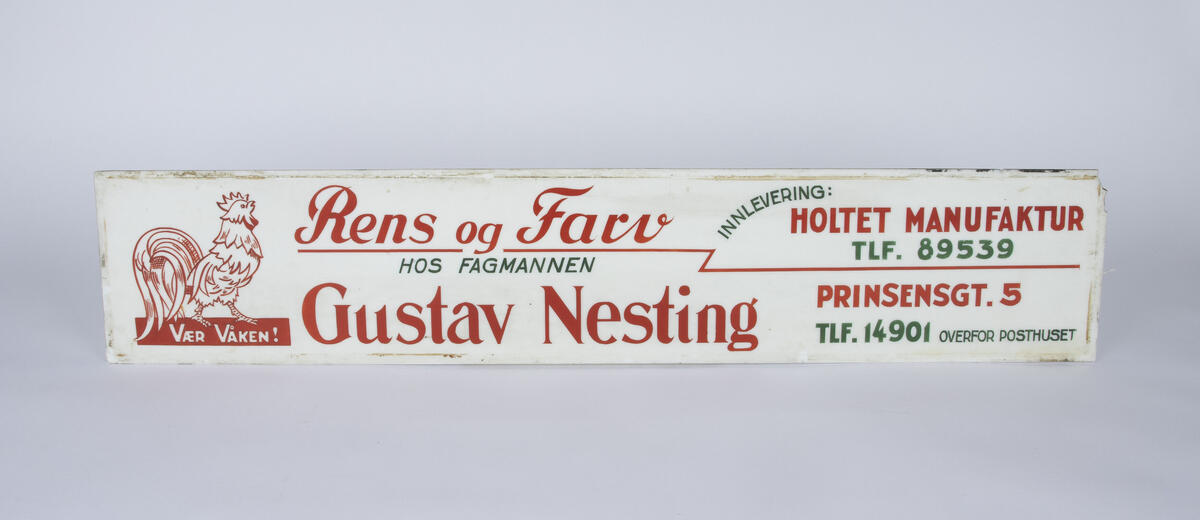 Hvitt skilt med rød og grønn skrift for Gustav Nesting rens og farv. På venstre side av skiltet er en hane med teksten "vær våken!" under. 