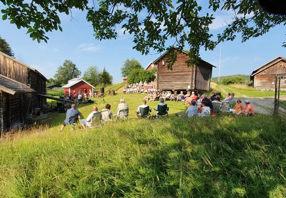 Konsert på Almenninga. Oversiktsbilde fra vegen. Sommer.