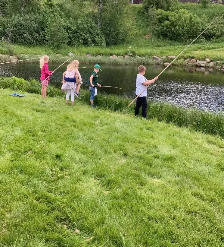 Barn fisker ved åa på Almenninga.