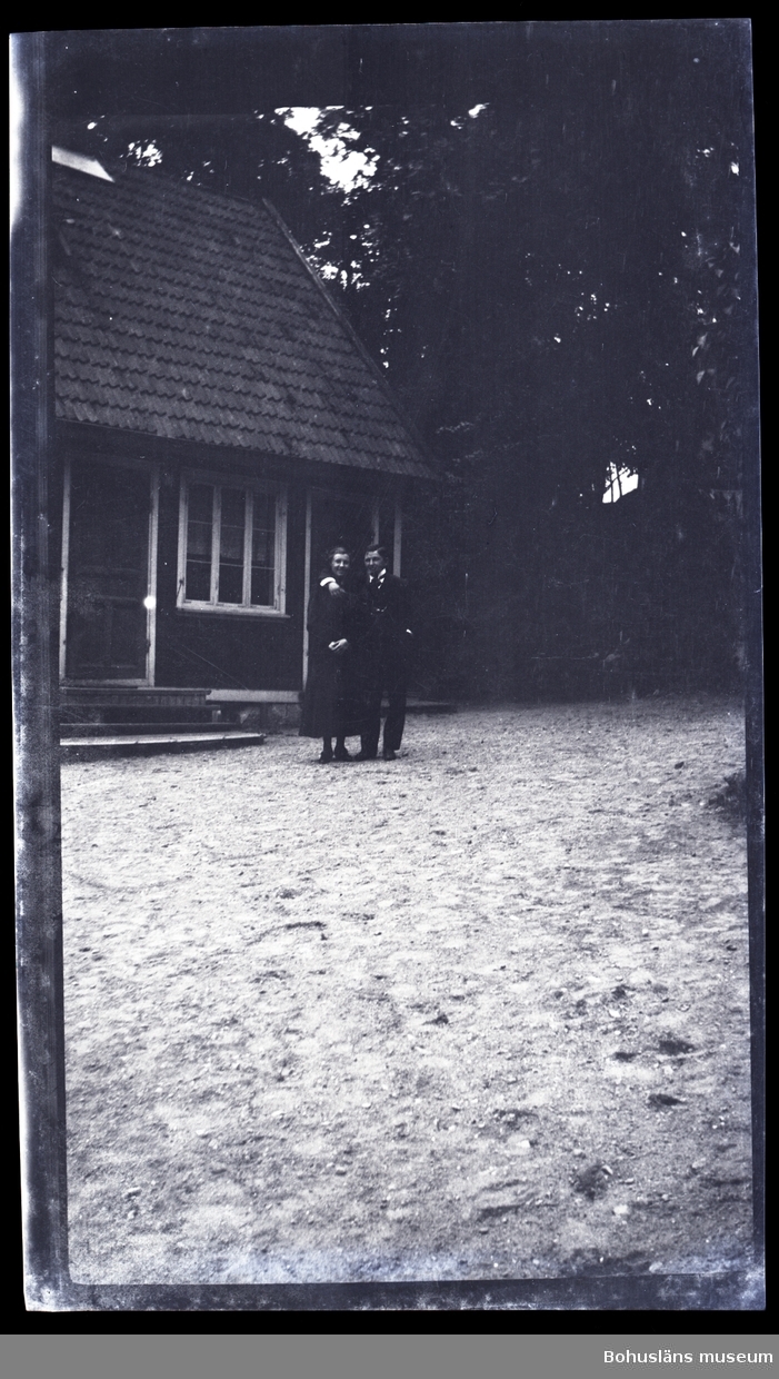Två personer ståendes framför ett hus.