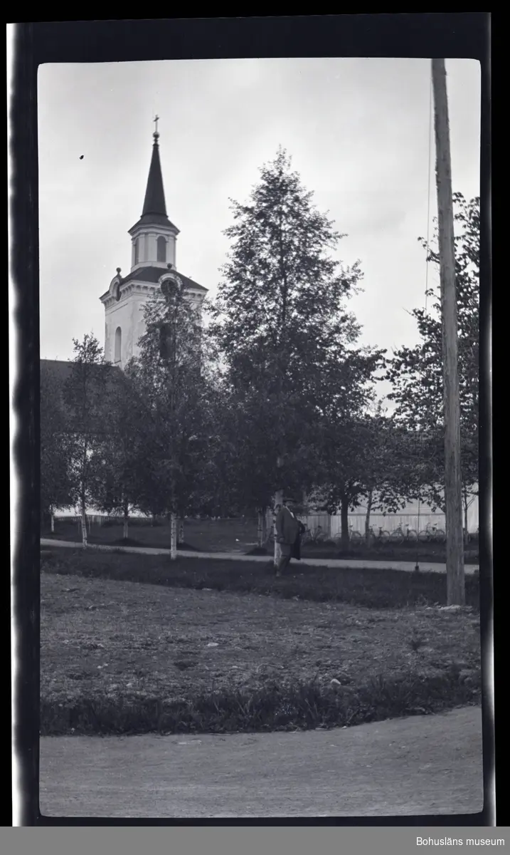 En person ståendes vid en allé framför en kyrka.