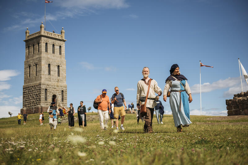 Mange mennesker vandrer fra Slottsfjellstårnet. Det er sol og sommer.