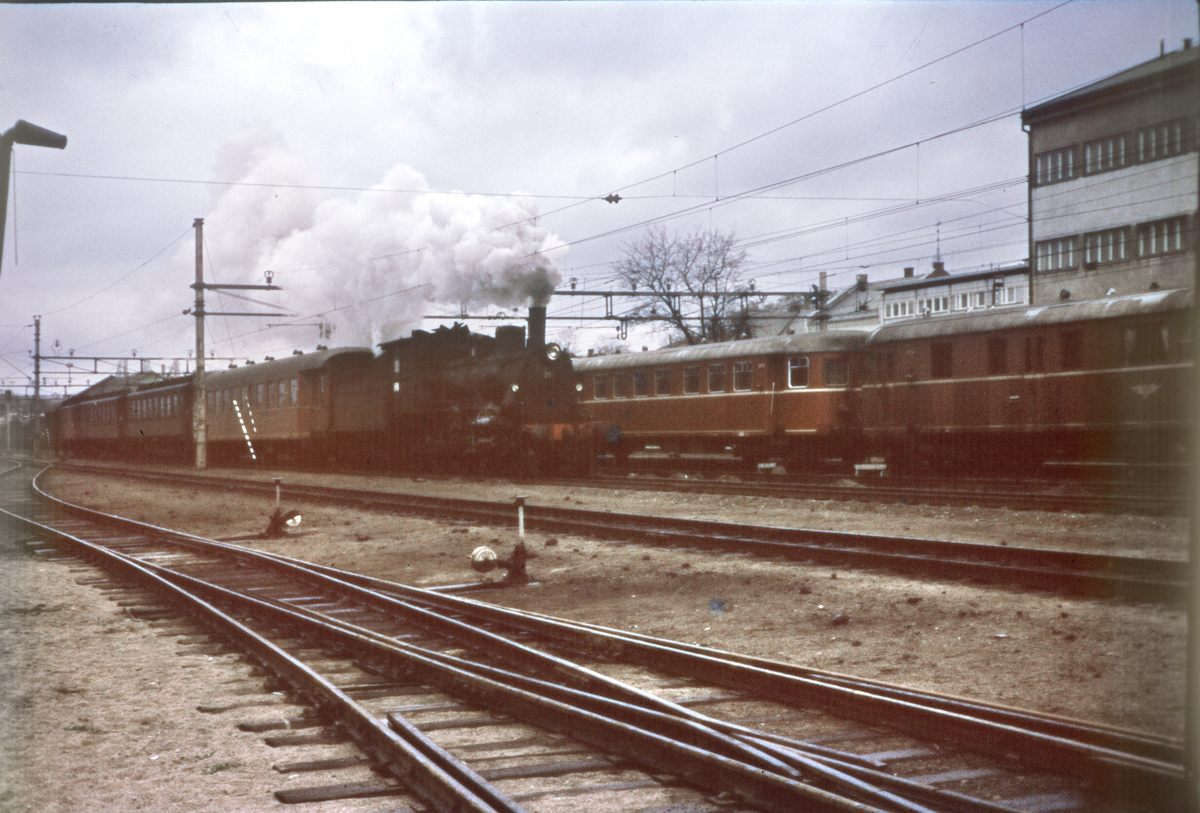 Damplokomotiv type 27a nr. 297 med persontog til Rørosbanen kjører ut fra Hamar stasjon
