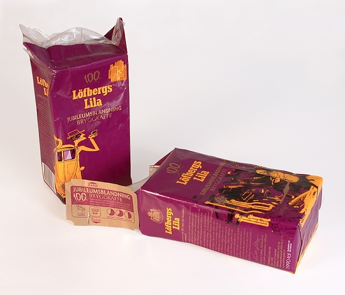 Rektangulärt paket av papper med innerpåse i genomskinlig plast. Paketet är öppnat. Paketet har lila färg med tryck i svart, gult och guld. Fram- och baksida har likadana tryck föreställande hus, människor och kaffekoppar med texten "Löfbergs lila jubileumsblandning. Bryggkaffe 500g. 100 år kaffespecialister sedan 1906". Illustrationen, som föreställer 1990-talet, är gjord av Will Barras. På kortsidorna text i guld, gult och vitt. En sida har en text om Löfbergs lilas historia. Den andra sidan har text om innehåll, dosering, beredning, förvaring och källsortering.  På denna kortsida finns även en vit ruta med svarta streck och nummer, en så kallad streckkod för affärerna att läsa av priset på. I botten på paketet datummärkningen 12-01-2007, som anger sista lämpliga förbrukningsdag. På toppen av paketet finns en klisterlapp som använts som förslutning. Den är guldfärgad med lila tryck. Text och bild om innehåll och användning.