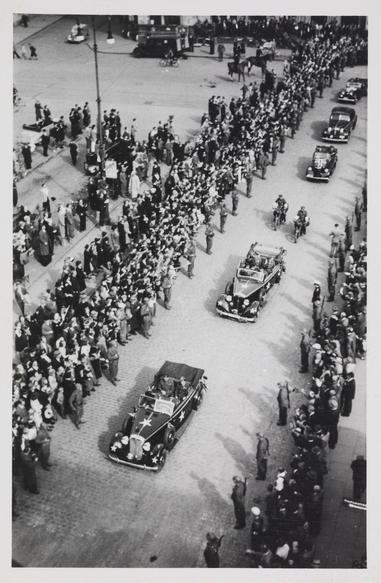 Del av bilkortesjen til Kronprins Olav, 13. mai 1945. De er på vei opp til Slottet. Bildet er tatt ved Østbanehallen.