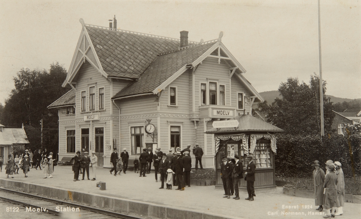 Postkort, Ringsaker, Moelv stasjon, Narvesenkiosk, reisende på perrongen, stasjonen med lys liggende panel,