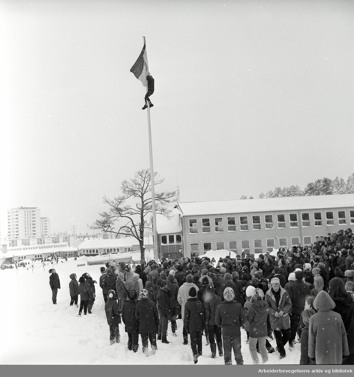 Demonstrasjon mot krigen i Vietnam. FNL-flagget (den nasjonale frigjøringsfronten for Sør-Vietnam) heises på Manglerud skole. Februar 1968
