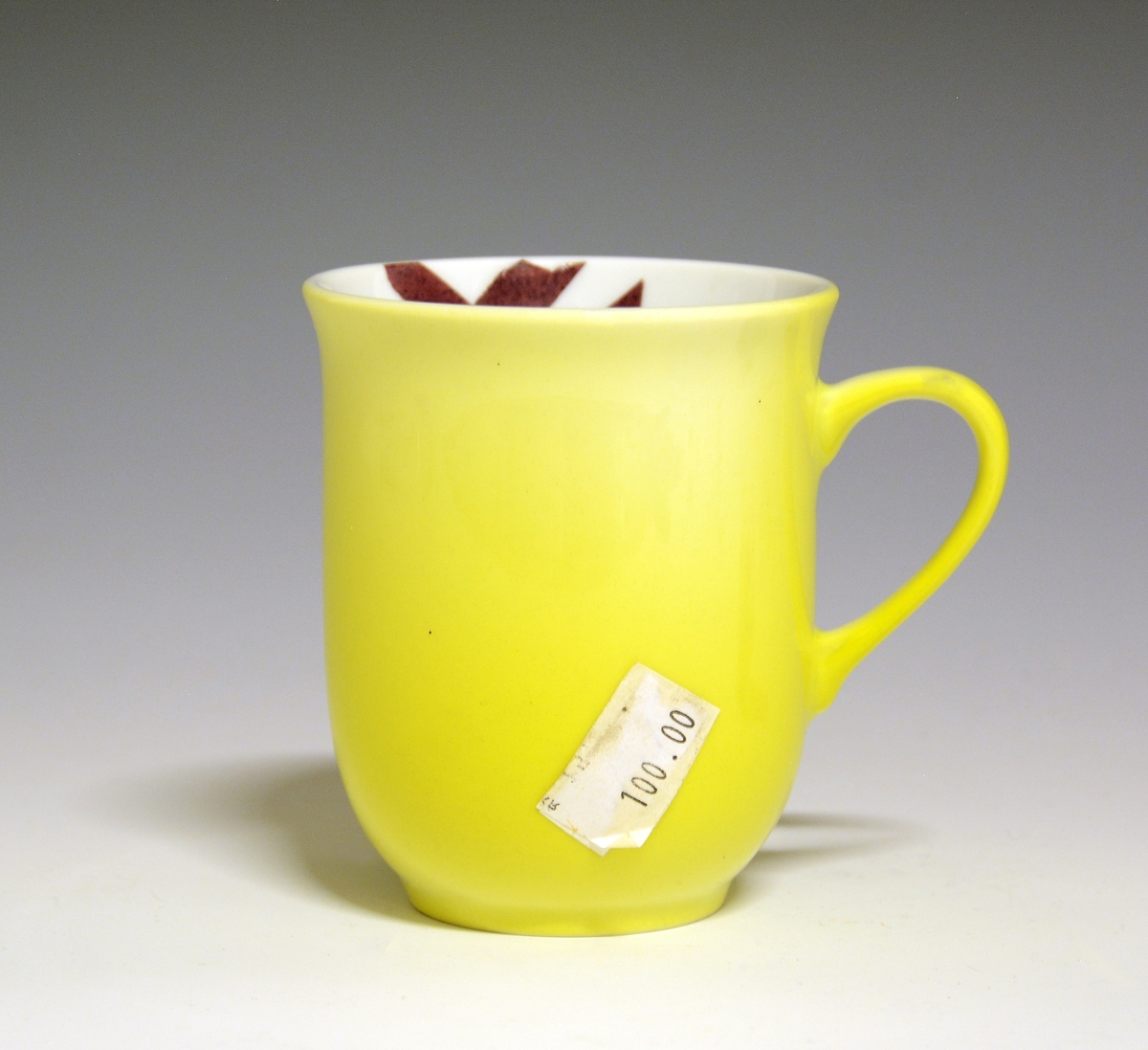 Krus av porselen med  hvit glasur. Heldekkende gul utvendig, innvendig "XL" med brede "penselstrøk". 
Modell: 2681