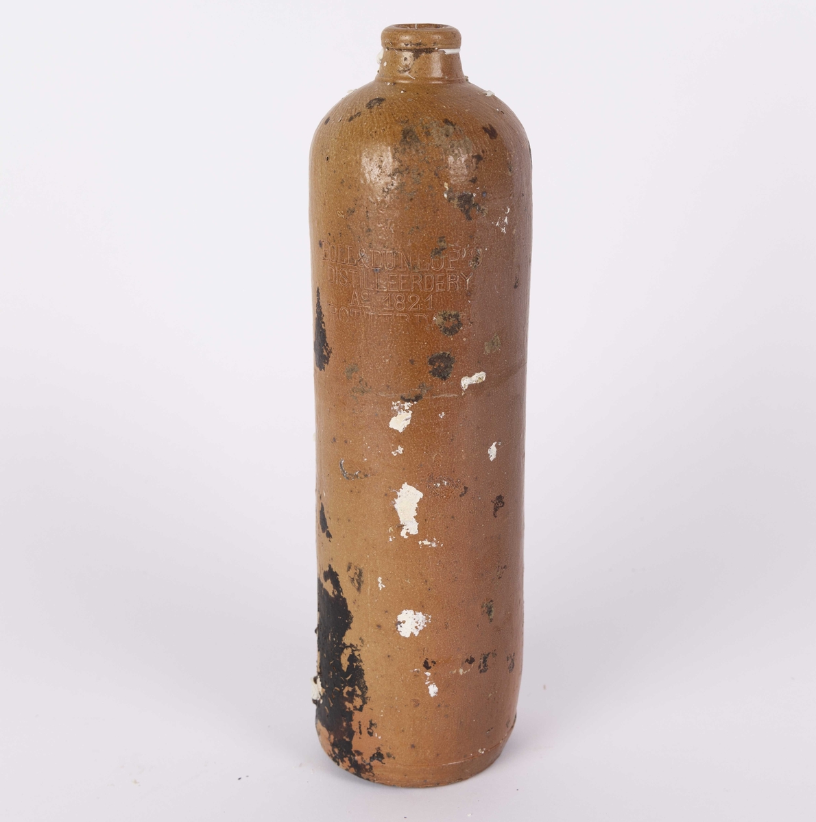 Selters flaske funnet i Nautasundet, Øygarden kommune. Høy, sylinderformet flaske i leirgods fra 1821. Transparant glasur. Innskrift.
