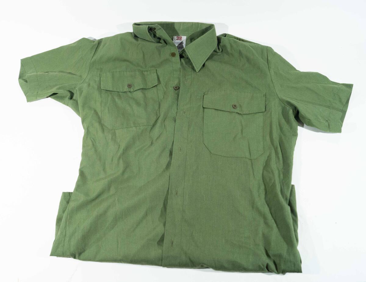 Kortärmad skjorta m/1968. Grön med gradbeteckning för kapten på axelhylorna.