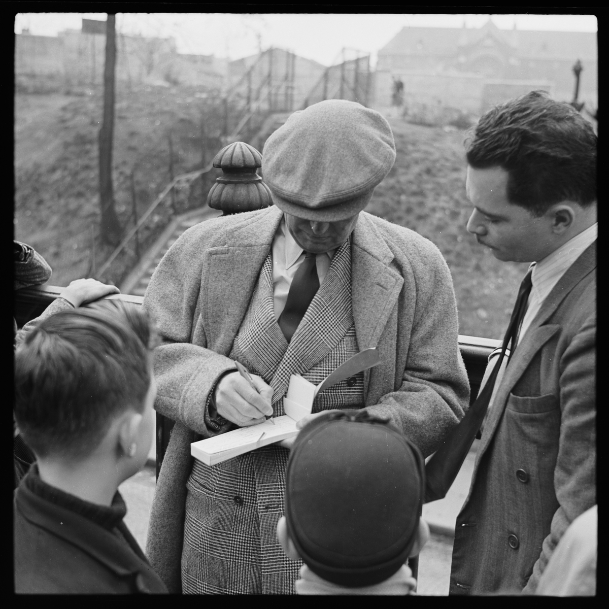 Maurice Chevalier skriver autografer.